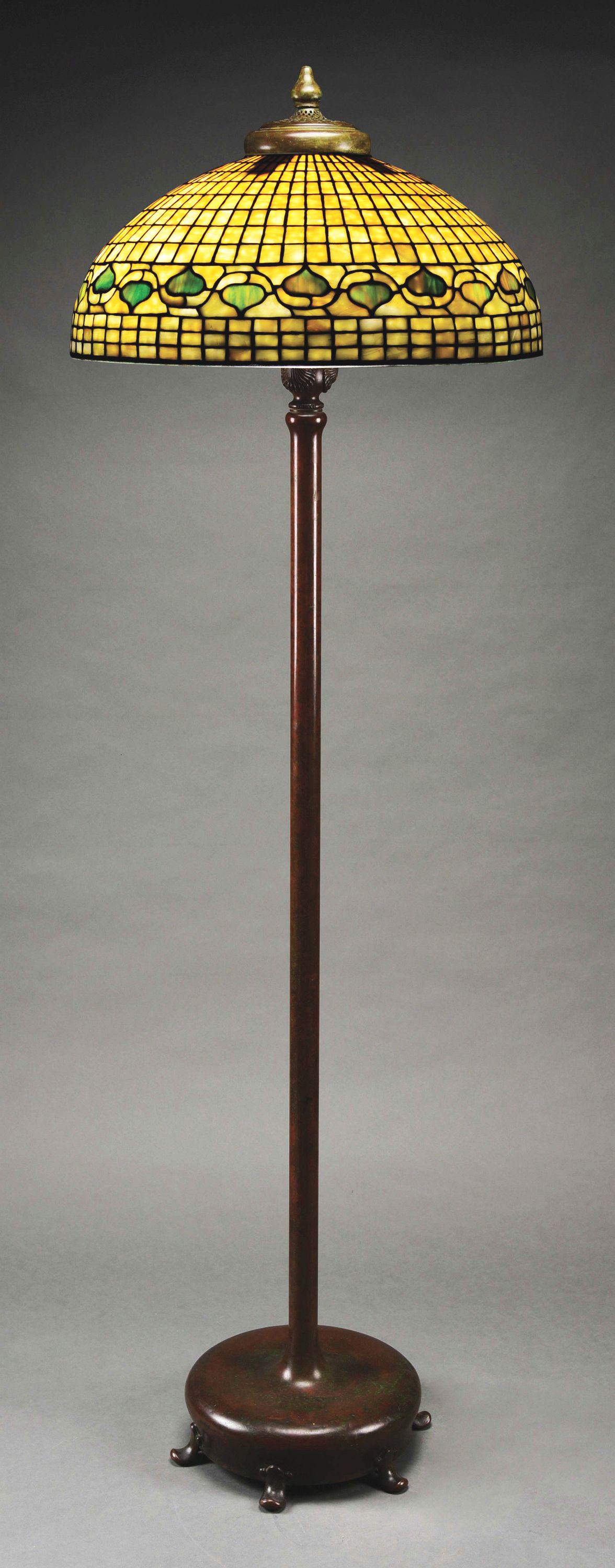TIFFANY STUDIOS LEADED GLASS FLOOR LAMP.: A beautiful leaded glass and bronze floor lamp by Tiffany Studios. The 20” shade features a leaf and vine (sometimes referred to as “Acorn”) pattern. The background glass is highly mottled yello