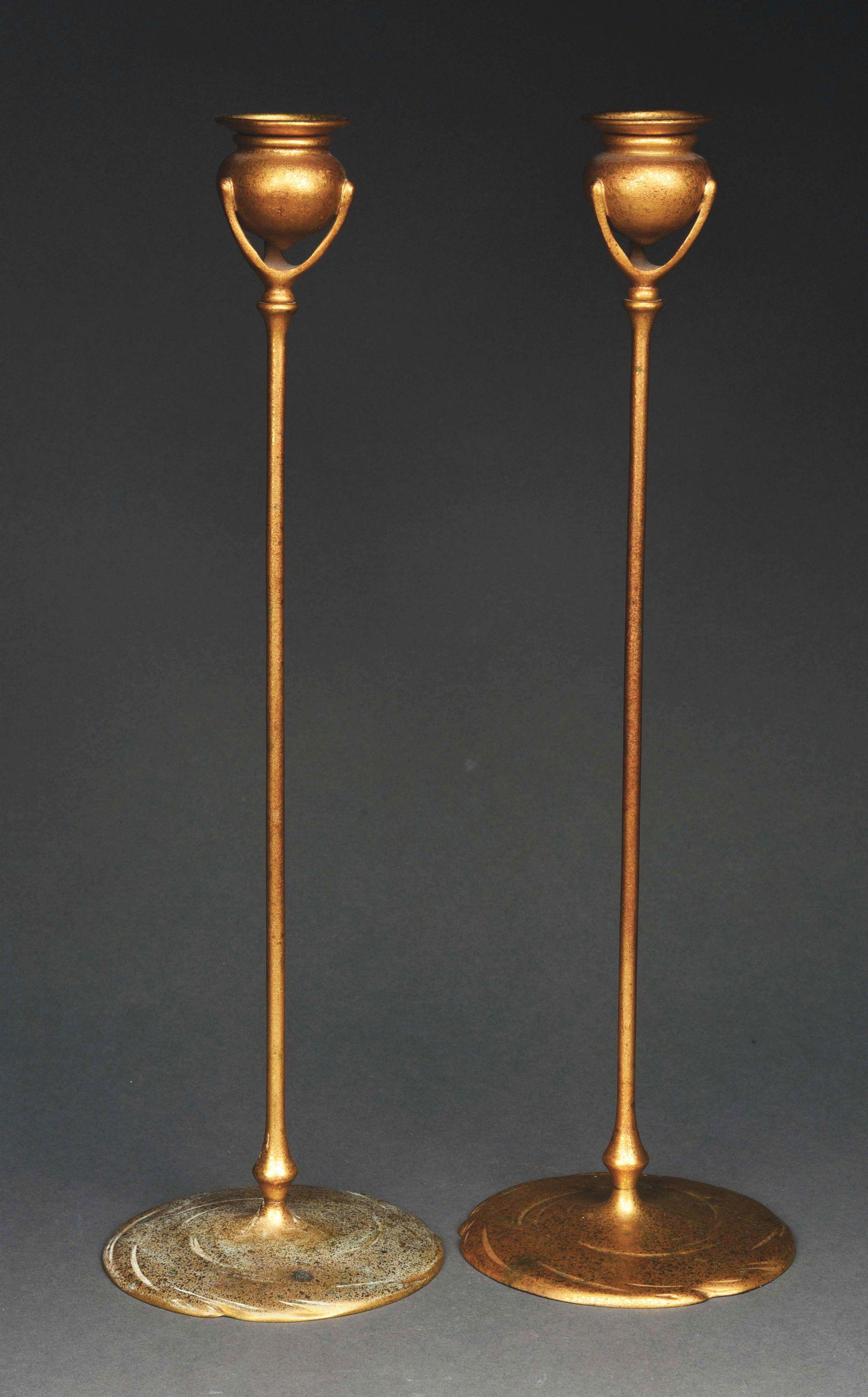 PAIR OF TIFFANY STUDIOS GILT BRONZE CANDLESTICKS.: A lovely pair of candlesticks by Tiffany Studios. Both candlesticks are finished in gold dore. They each measure 19” in height and are in very good condition, free of breaks, dents, bending, or defo