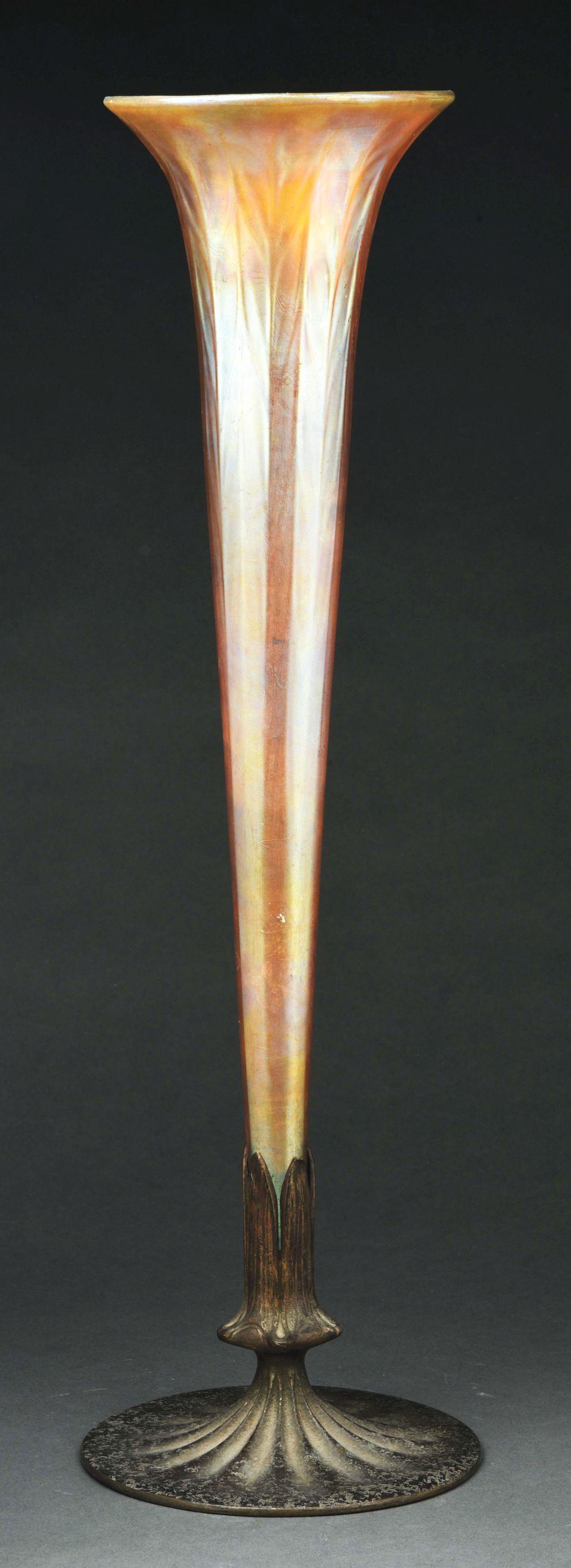 TIFFANY STUDIOS TALL FAVRILE GLASS VASE WITH BRONZE: A tall Favrile glass vase by Tiffany Studios with bronze base. The trumpet shaped Favrile glass vase features gold glass with pink and purple iridescence. The glass portion itself measures an impressi