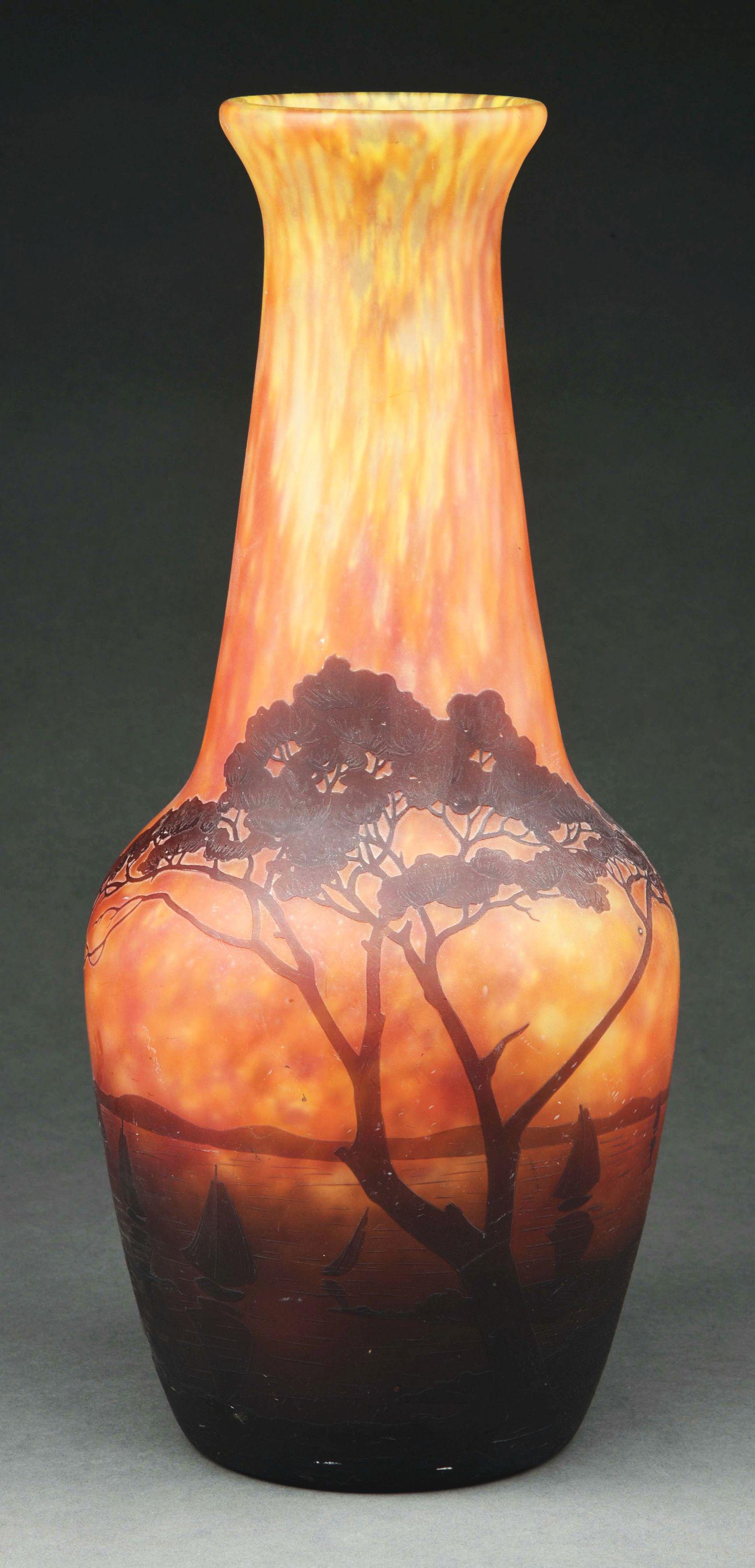 LARGE DAUM NANCY CAMEO VASE.: A large cameo cut vase by Daum featuring a sunset scene with green and yellow background. With cameo cut trees and boats on a lake with mountains in the distance. In good condition, free of cracks or