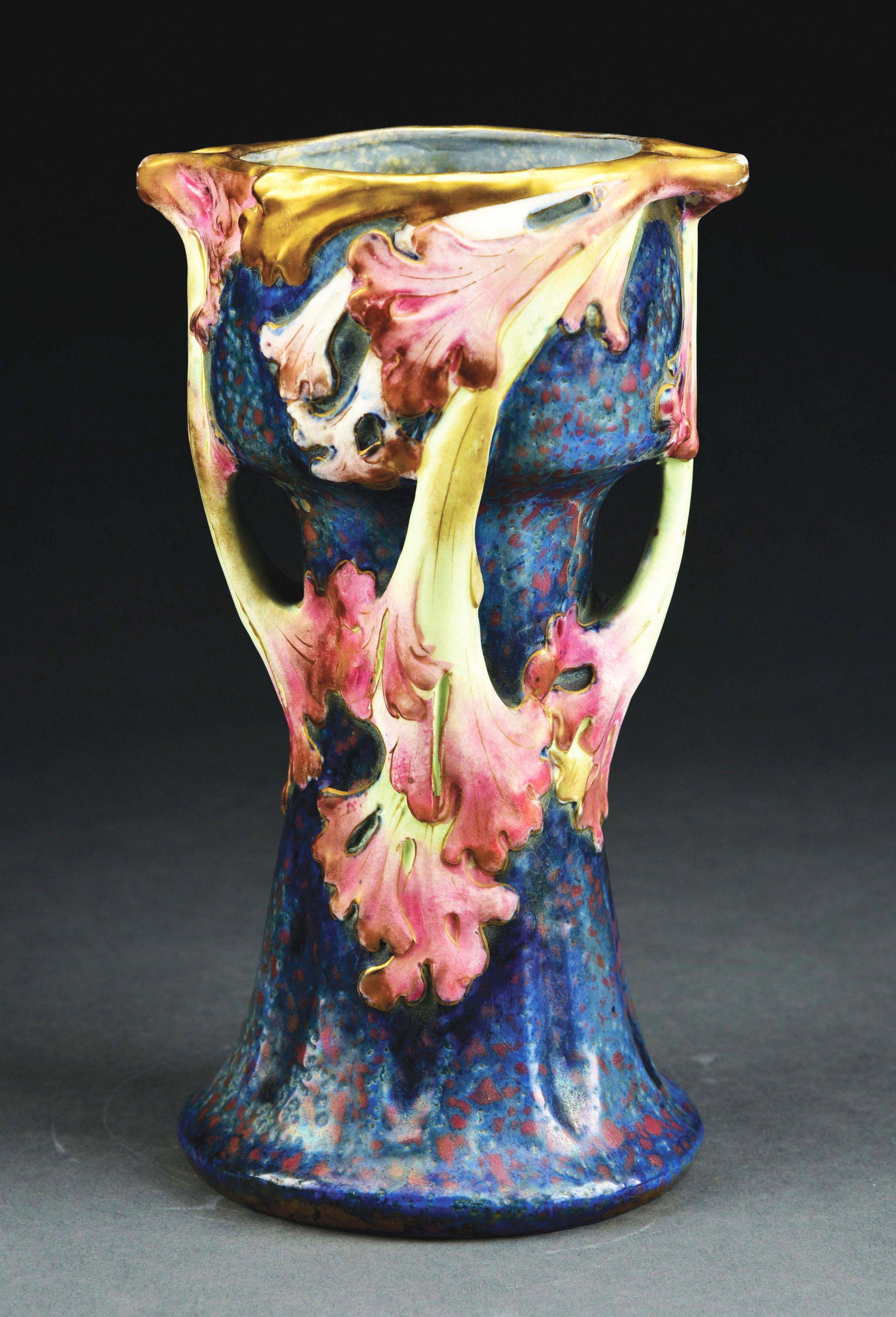 AMPHORA FLORAL VASE WITH LEAF HANDLES.: Vibrant blue pink glazes on body with applied pink cream glazed leaves and gold gilt rim. Amphora Oval, Austria Oval, Crown Mark, impressed "2571", c. 1900. A similar model is illustrated in "Monsters