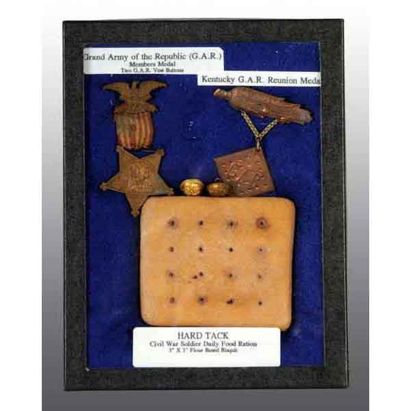 Lot of 4: Civil War GAR Pins.: Includes one Kentucky GAR Reunion pin shaped like a corn cob with a piece of hardtack hanging below, one GAR Members medal, two GAR vest buttons, and one souvenir piece of old hardtack. Largest: 3" T.