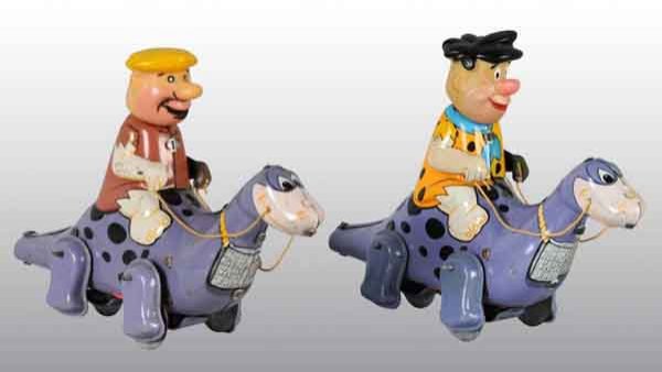 Lot of 2: Tin Linemar Flintstones Wind-Up Toys.: Japanese. Marked "Hanna-Barbera Productions 1963". Includes Fred Flintstone and Barney Rubble riding Dino. Some scratching and wear throughout. Both: 8" L. (Very Good).