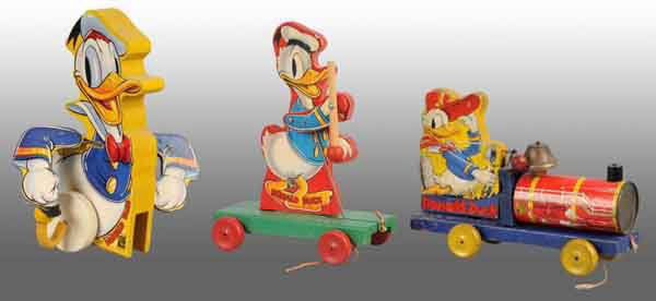 Lot of 3: Fisher Price Disney Donald Duck Toys.: American. Includes no. 900 Strutting Donald with stick but missing feet, one Donald choo-choo, and no. 400 Donald Drum Major. Largest: 10" T. (Very Good).