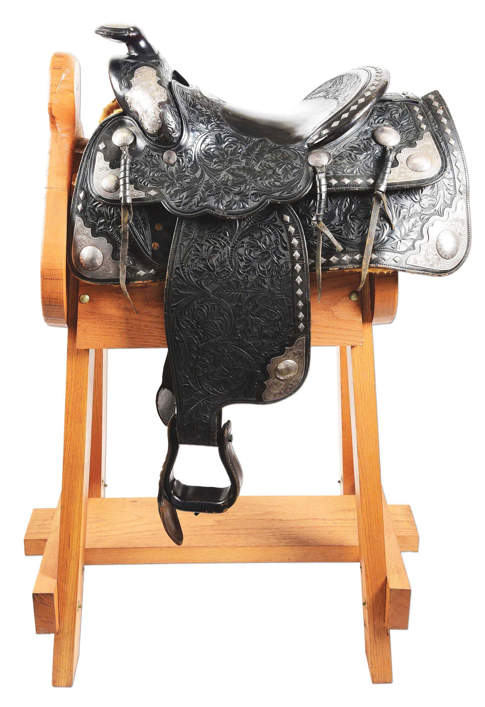 STERLING SILVER PARADE SADDLE.: A spectacular silver mounted parade saddle with extensive leather carving and engraved silverwork. The saddle is marked with a silver plaque "COW COUNTRY SADDLERY". Saddle is mounted with sterling sil