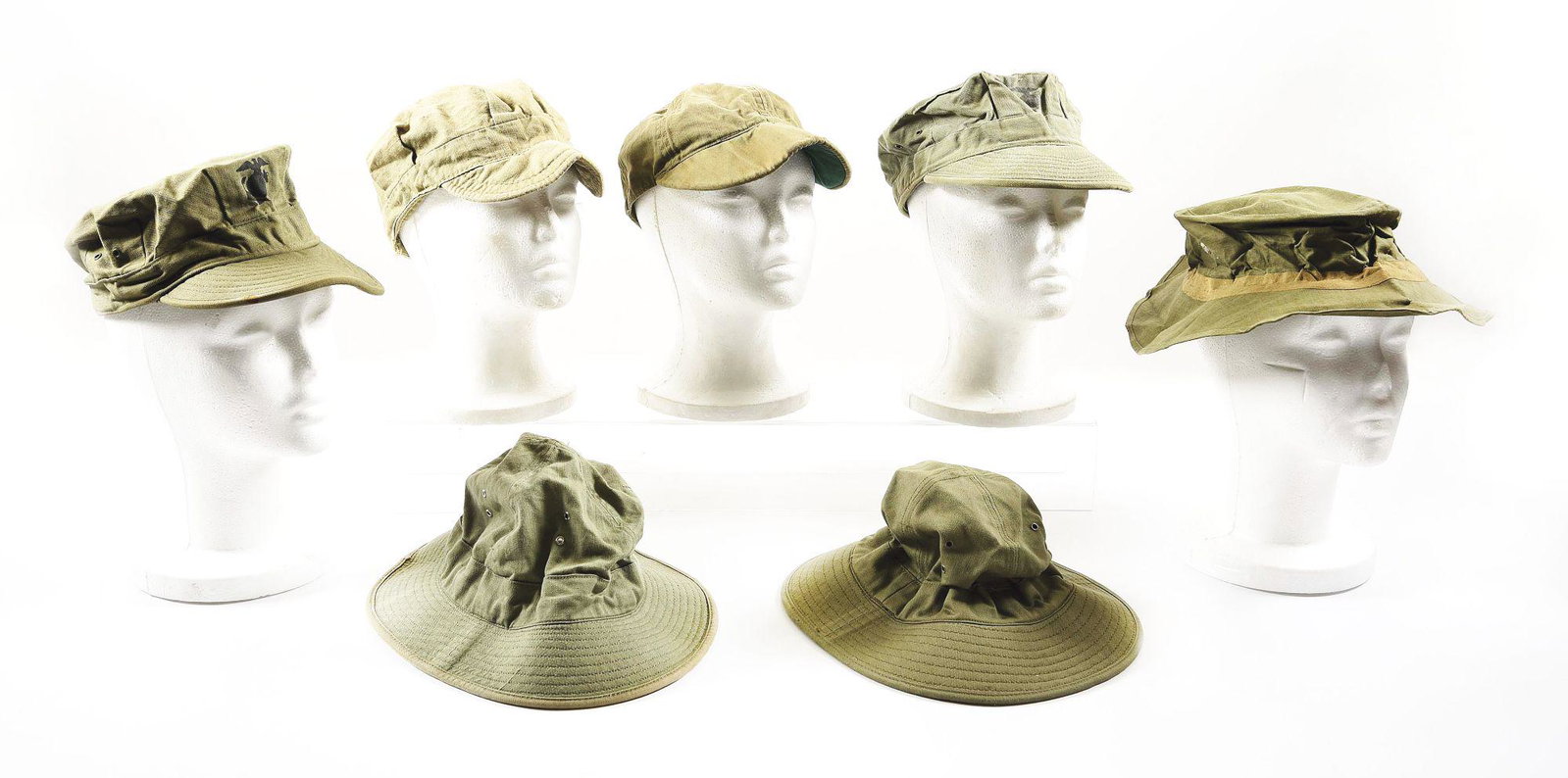 LOT OF 7: WORLD WAR II USMC RAIN HAT, FATIGUE HATS, AND: Lot consists of (A) World War II USMC rubberized jungle rain hat stamped "U.S.M.C. ARCHER RUBBER Co. NOm-42455 NOVEMBER 30,1943 SIZE 7 3/8". The hat is stiff and exhibits slight tarnishing. CONDITION: