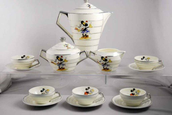 French Walt Disney Mickey & Minnie Mouse Tea Set.: Includes large pitcher with lid, creamer, eight cups, sugar pot with lid and eight plates. Marked "Mickey Mouse Deposee" on bottom of better pieces. Also marked "Walt Disney." Some minor chipping to l