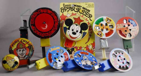 Lot of 9: Character Sparkler Toys.: Circa 1950s, 60s and 70s. Includes tin, plastic, some sparklers and some noise makers with sirens. Includes two fire chiefs including Ed Wynn, one with bird and dog, one Jetsons, one Flash Gordon, and