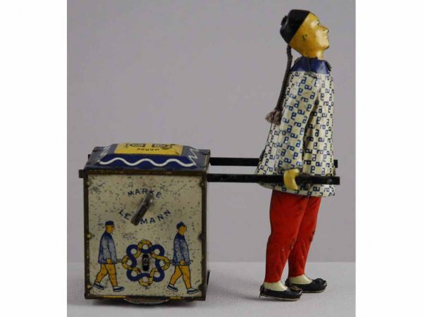 Tin Litho Wind-Up Lehmann Nu-Nu Toy.: Pre-war. Germany. Depicts Cooley pulling tea cart. Nice lithography with some moderate spotting and wear throughout. 6" T.