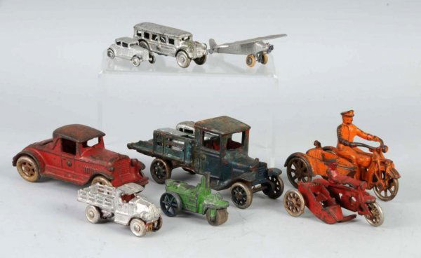 Lot of 11: Cast Iron & Slush Mold Toys.: Includes Arcade stake truck with broken back end, cast iron coupe, two cast iron motorcycles with sidecars, small repainted cast iron bus and stake truck, Tootsie Toy airplane, three repainted slush m