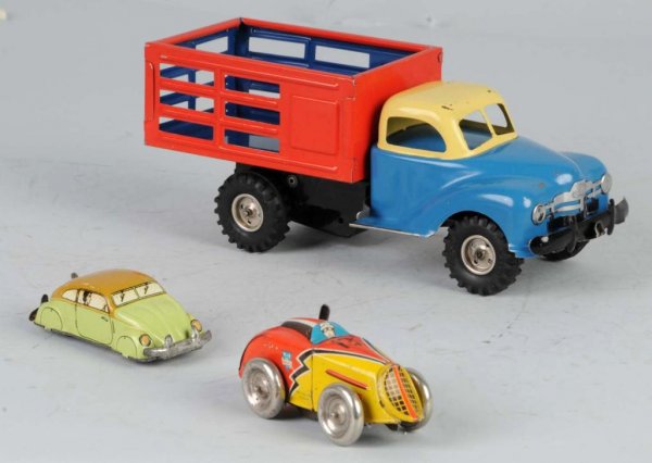 Lot of 3: Tin Vehicle Wind-Up Toys.: German. Working. Includes one Gama stake truck, one Volkswagen marked "US Zone", and one small race car marked "US Zone". Some scratching. Largest: 8" L.