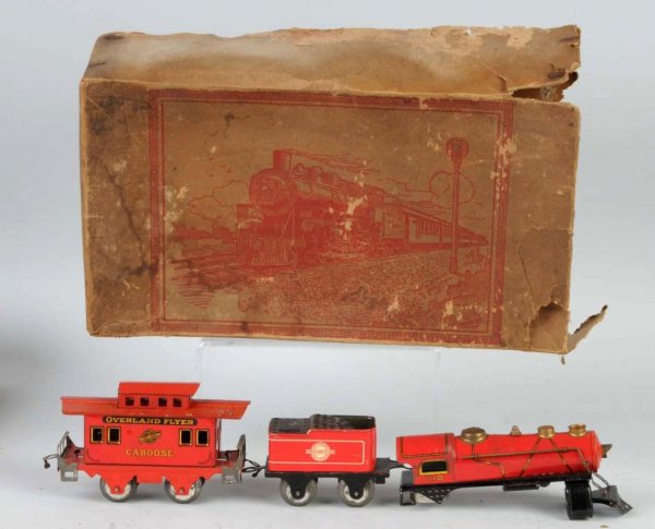 Tin Overland Flyer Wind-Up Freight Train Set.: Includes no. 1110 steam-type locomotive. Motor is disassembled but present. Overland Flyer tender and Chicago & Northwestern Line caboose. Other freight cars are missing. Includes original box missing
