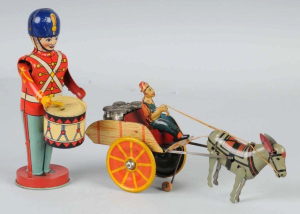 Lot of 2: Tin Litho Wind-Up Toys.: American. Working. Includes one Chein drummer boy missing one drum stick and one Unique Art Hee Haw wagon toy. Largest: 10 - 1/2" L.