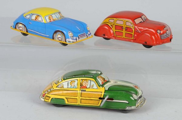 Lot of 3: Tin Automobile Toys.: Includes one wind-up Marx Woody Station Wagon, one wind-up Chein Woody Station Wagon, and one French-made Porsche. Largest: 6 - 3/4" L.
