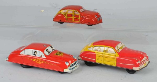 Lot of 3: Tin Vehicle Toys.: Includes one Chein wind-up Woody Wagon, one American-made Woody Wagon push toy, and one Marx friction Fire Chief car. Moderate scratching throughout, especially to Chein car. Largest: 7 - 1/2" L.