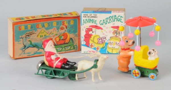 Lot of 2: Celluloid Wind-Up Toys.: Japanese. Working. Includes one Santa on sled and one animal pushing baby carriage. Both include original boxes. Largest: 8" L.