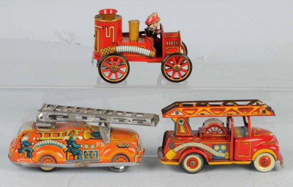 Lot of 3: Tin Fire Truck Friction Toys.: Japanese. Working. Two are ladder trucks and one is a pumper. Nice, colorful lithography. Largest: 6 - 1/2" L.