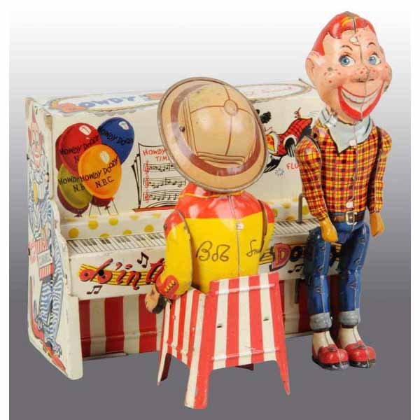 Tin Litho Unique Art Howdy Doody Band Wind-Up Toy: American. Working. Depicts Howdy Doody and Buffalo Bob dancing and playing piano. All original and complete. Some spots of wear, pitting, and oxidation to metal. 8" T.