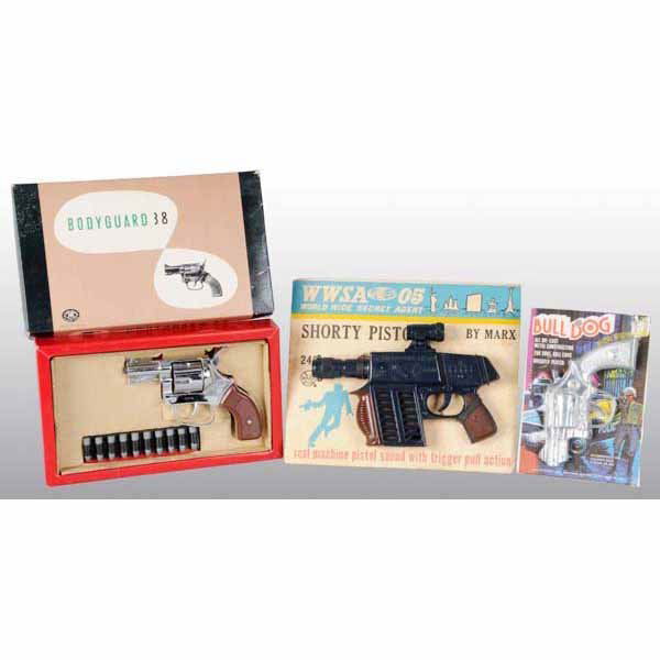Lot of 3: Toy Guns.: Includes elaborate and very real looking 1970s boxes 38 special with bullets. Toy Machine Gun on card and Bulldog special card. All in mind condition. Old store stock. Largest: 9" x 11".