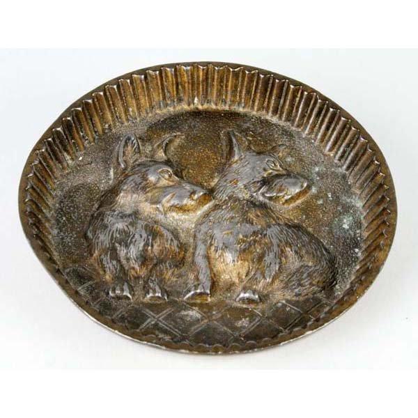 Scottie Pin Tray.: Description Spelter. Made by Jennings Bros. Round tray with fluted edge and two Scotties in relief. Marked "JB, 2946". Condition (Very Good). Size 3 - 1/2" Dia.