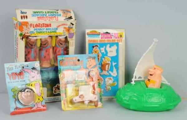 Lot of 5: Hanna-Barbera Flintstones Toys.: Circa 1960s to 1970s. Includes Barney Rubble Turtle Boat, Fred Flintstone Yo-Yo, Fred Flintstone Flintmobile, Draw & Color set, and Fred Flintstone Target Game. All are in their original packaging. Si