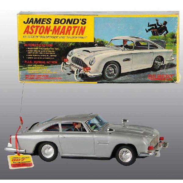 Tin Gilbert James Bond Aston-Martin Batt.-Op Toy.: Japanese. Working. Original tag and plastic ejection man. Very little wear overall. Includes original box which shows realistic depiction of Sean Connery driving vehicle. Advertisement for James Bond 