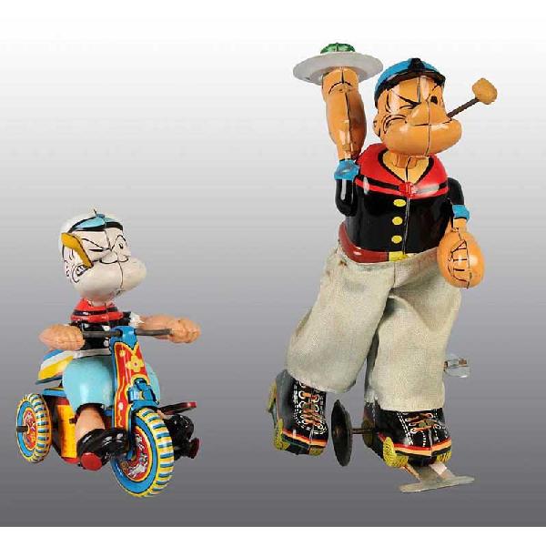 Lot of 2: Tin Linemar Popeye Wind-Up Toys.: Japanese. Working. Includes one skater toy with original pants faded from blue to white. Original pipe bowl. Marked "King Features Synd." on back. Part of rubber edge on bottom of wheel is broken. Als