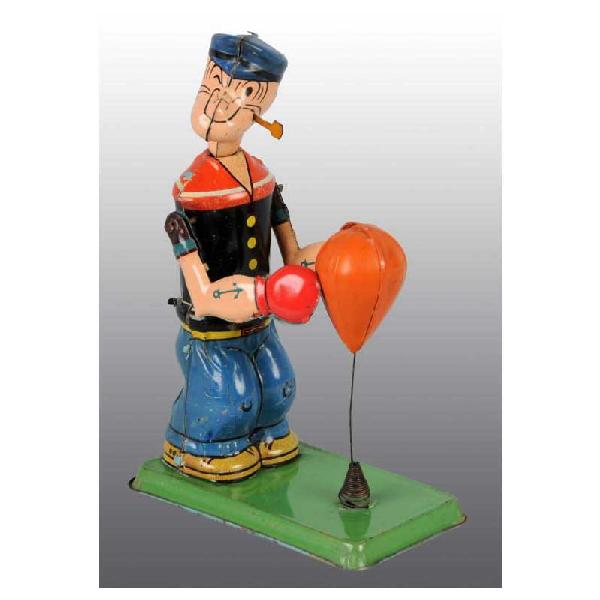 Tin Marx Popeye Floor Punching Wind-Up Toy.: American. Working. Tin figure and base with original celluloid bag. Original pipe. Bag is separated. Bottom of green base with some wear and scratching to Popeye's knees. 7 - 1/2" T.