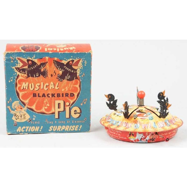 Tin Mattel Musical Black Bird Pie Toy.: Crank-operated. Plastic black birds. When in operation, black birds pop up out of pie. Includes original box. Size: 9 - 1/2" x 4 - 1/2".