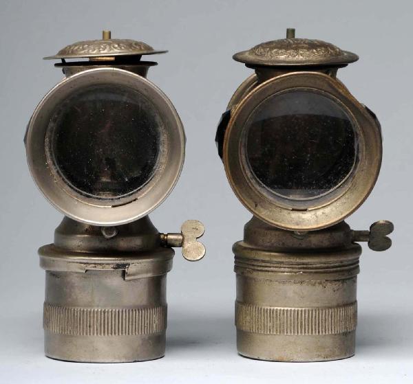 Lot of 2: Bicycle Lanterns by Solar.: Both with ruby red faceted glass inserts on sides. One with clamp on back to attach to a carriage or bike and one with a slight dent on top. Size: Each: 7" T.