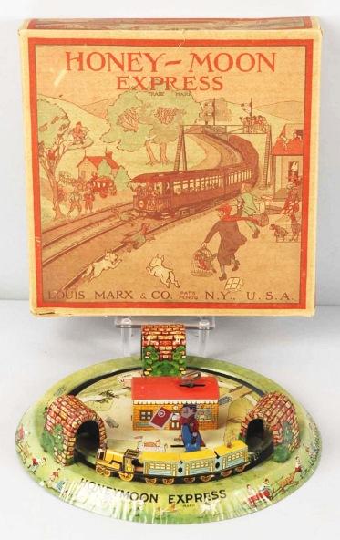 Tin Litho Marx Honeymoon Express Wind-Up Toy.: Early variation with man in middle with flag that moves up and down. Minor scratching and wear. Includes original crisp box with nice lithography. Size: Box: 9 - 1/2" x 9 - 1/2".