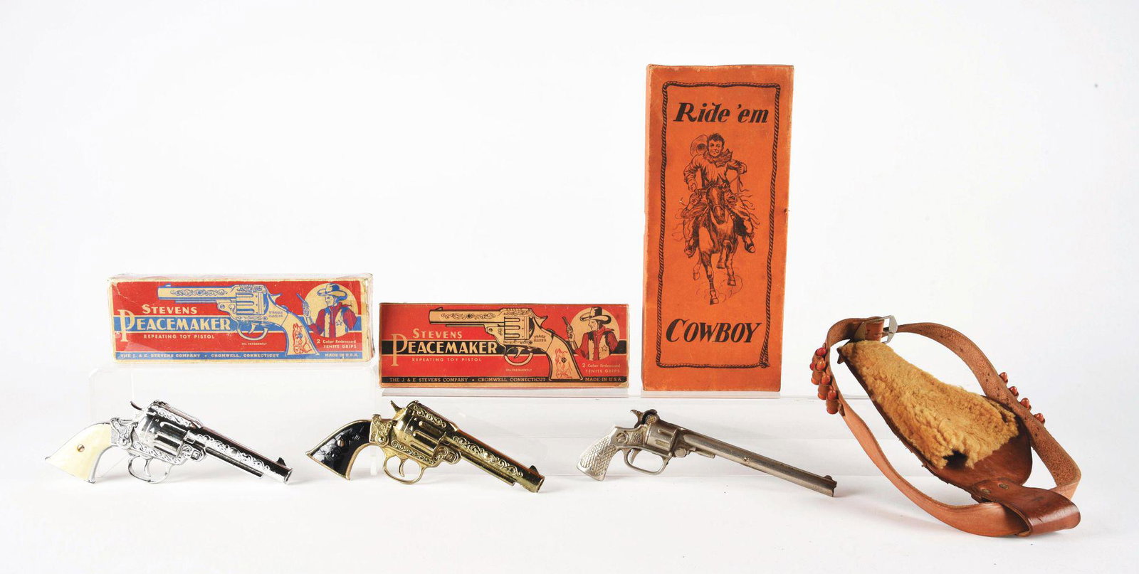 LOT OF 3: EARLY KENTON AND STEVENS TOY CAPGUNS.: All in original boxes. There is a 1933 Kenton Two Time Ride'em Cowboy pistol with holster and nice depiction of cowboy on box. Holster has four plastic bullets and is embossed "Two Time" and an "S" on