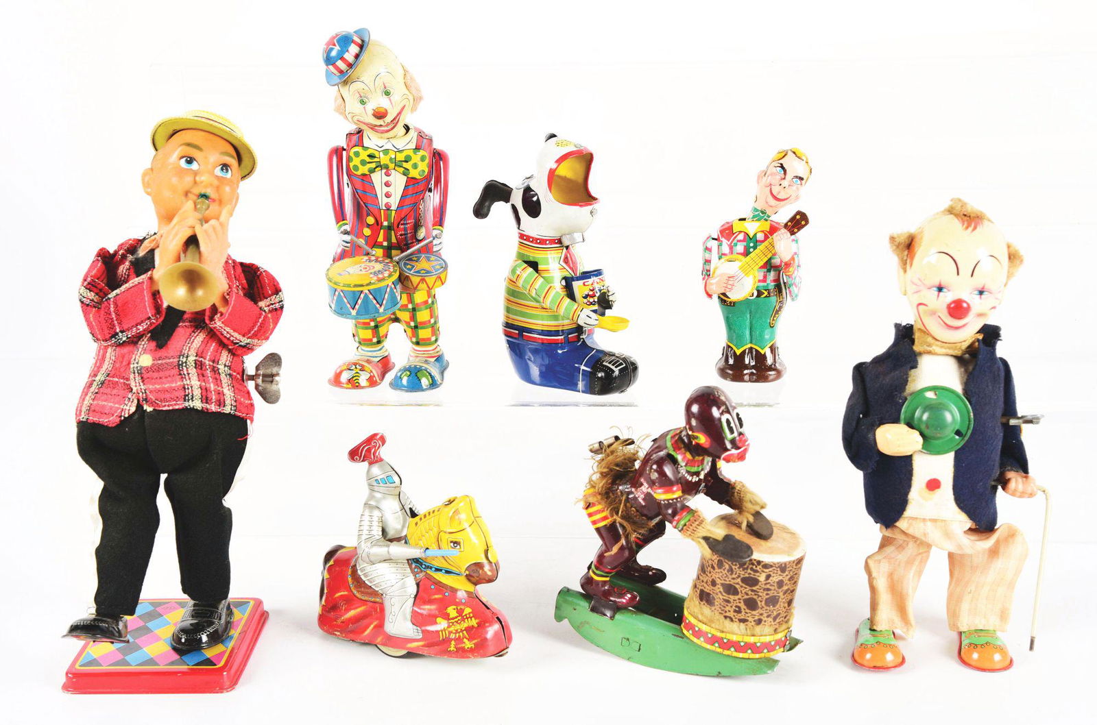 LOT OF 7: VARIOUS TIN LITHO AND VINYL JAPANESE WIND-UP: Candy Loving Puppy, Clown Whirl Tail, Alps Clown Drummer, Linemar Banjo Player, Haji Knight, African Drum Player, and Trumpet Player with vinyl head. Various conditions. Condition: (Very Good - Excell
