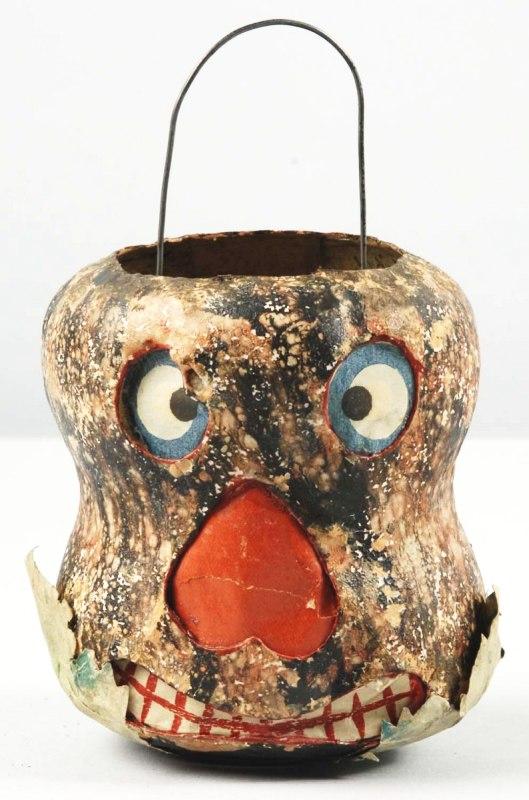 Paper Mache Tree Trunk Jack-O-Lantern.: German. Extremely rare. Original tin candle enclosure. Original leaf base with paper mouth, nose, and eyes. Size: 4" T.