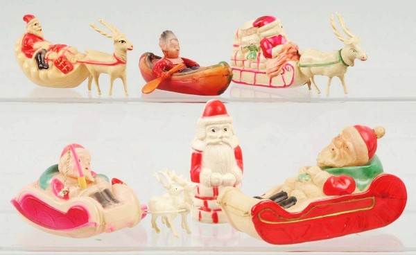 Lot of 7: Celluloid Santas.: Includes three with reindeer and one in a canoe. Size: Largest: 5" L.
