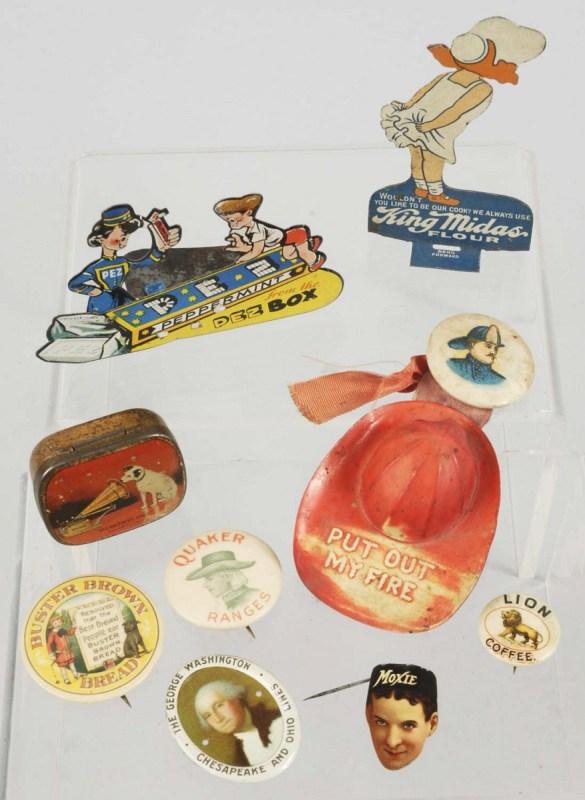 Lot of 9: Advertising Buttons & Tin Pieces.: Includes one for King Midas Flour, one Moxie pin, one Buster Brown pin, one Fireman's pin with helmet, one Lion Coffee celluloid button, one rare Pez clicker, and other items. Largest: 3 - 1/2" T. (Ve
