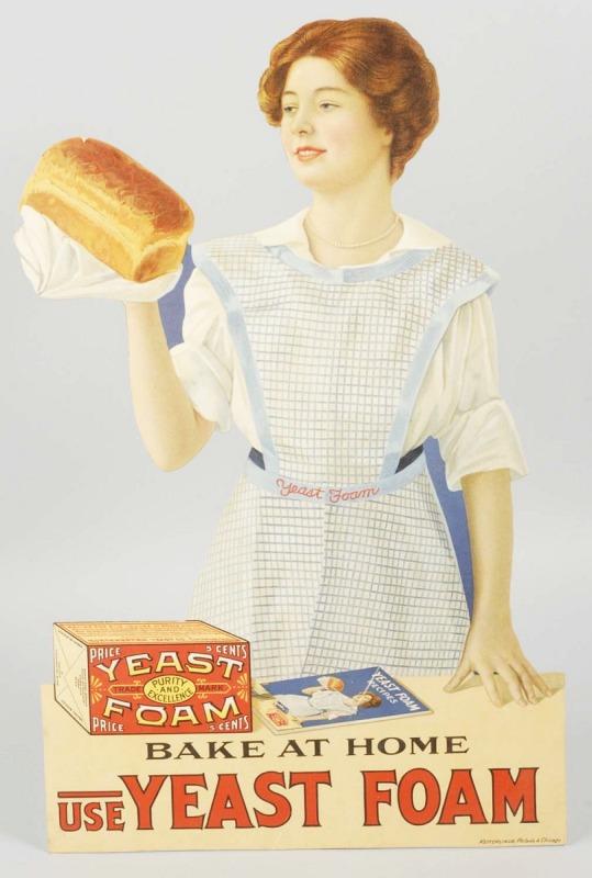 Cardboard Yeast Foam Advertising Sign.: Made by Ketterlin in Chicago. Depicts a beautiful young lady holding up a loaf of bread. 20" x 12 - 3/4". (Near Mint).