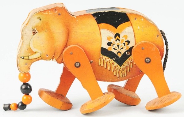 Early Fisher Price Go'n'Back Elephant Wind-Up Toy: Paper on wood. Working. Original tail and trunk but missing oil cloth ears. Some scratching and wear to paper. 11" L. (Very Good).