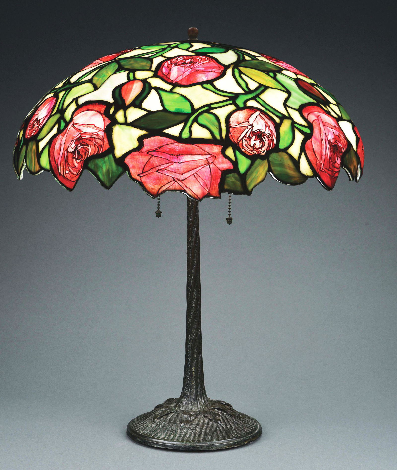 JOHN MORGAN AND SONS ROSE LEADED GLASS LAMP.: A beautiful leaded glass lamp with rose pattern by John Morgan and Sons, New York, c. 1905. The 19” diameter leaded glass shades features a rich cream colored background with green streaks, deco