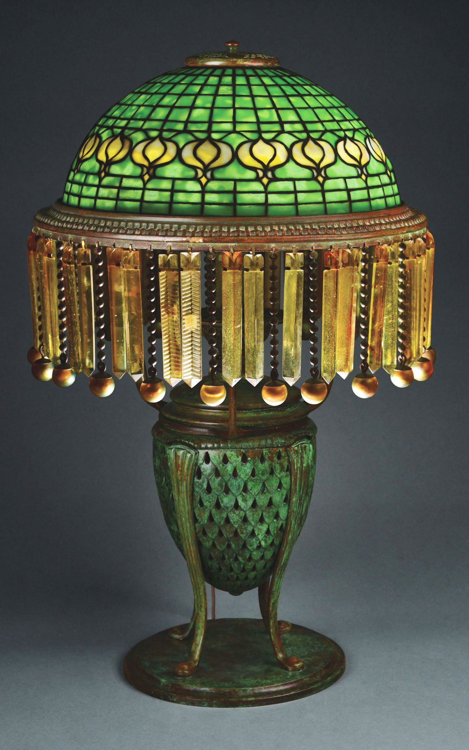 POMEGRANATE PRISM TABLE LAMP.: A rare Tiffany Studios leaded stained glass, cast bronze and Favrile glass pomegranate prism table lamp, decorated with a leaded stained glass pomegranate pattern shade with a belt of white-yellow mot