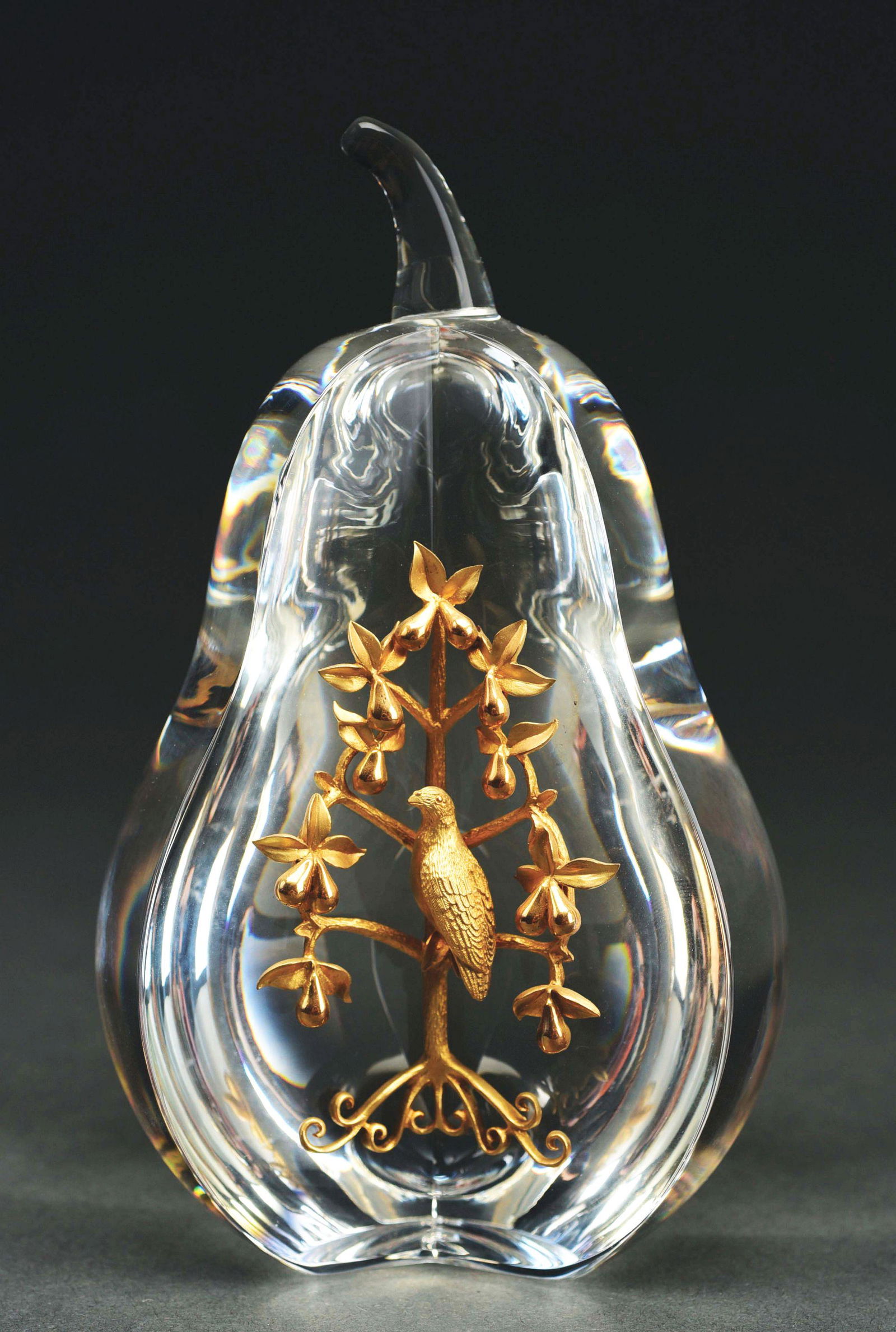 STEUBEN GLASS PARTRIDGE IN A PEAR TREE PAPERWEIGHT.: Steuben Glass partridge in a pear tree paperweight designed by Lloyd Atkins, c. 1968. 18K yellow gold, in original red box and outer grey box. 5 - 3/4" T. No chips, cracks or scratches. Condition: (Ex