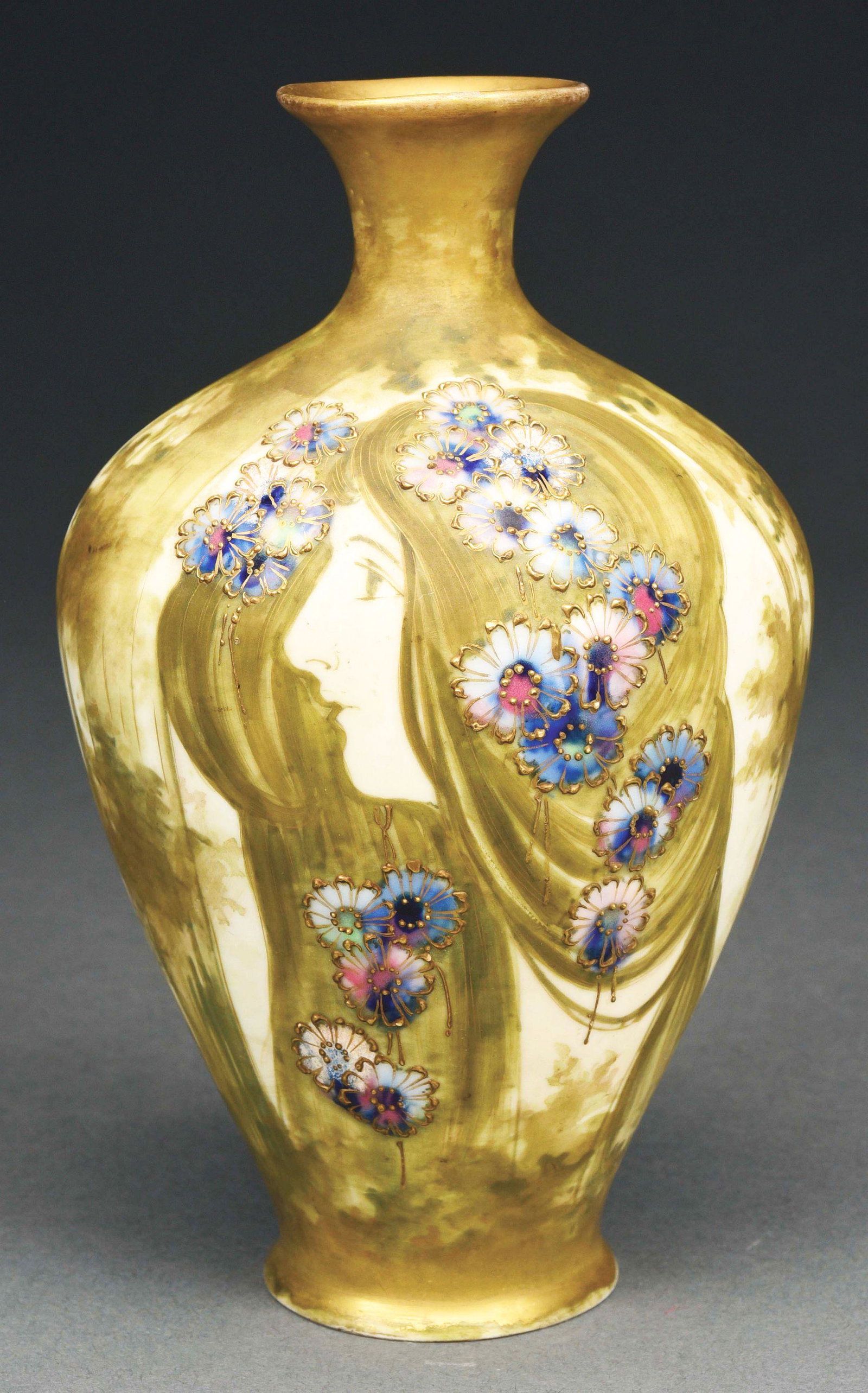 AMPHORA, MATTE AND ENAMEL GLAZED PORTRAIT VASE.: Portrait with applied high fired multicolored flowers and gold gilt. Marked RSTK, NK, Nikolaus Kannhauser impressed “471“. Similar examples are illustrated in "Monsters and Maidens: Collec