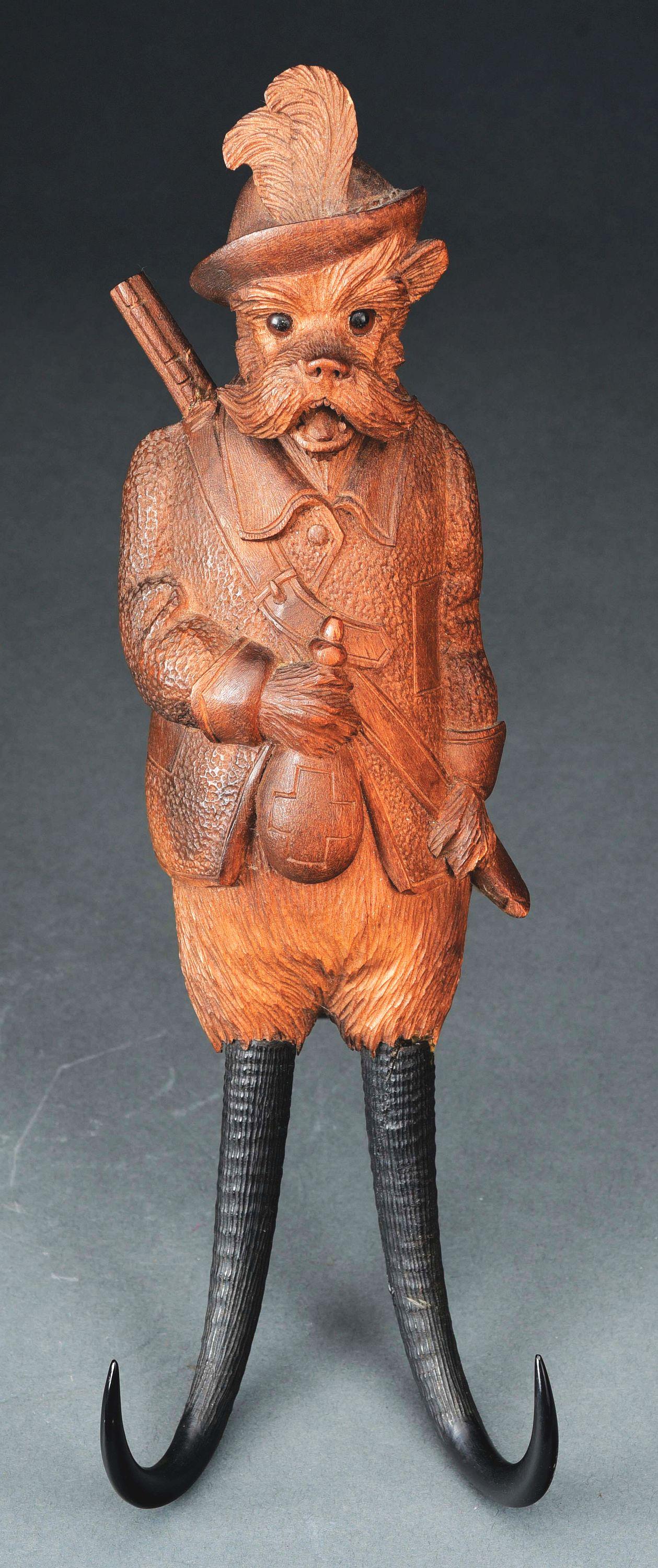BLACK FOREST CARVED WOODEN MUSICAL COAT HOOK.: This lot consist of a Black Forest carved wooden musical coat hook. Swiss made, late 19th century. In the form of dog hunting outfit, containing 4 air cylinder movement, 16" tall. Glue repair to gun t
