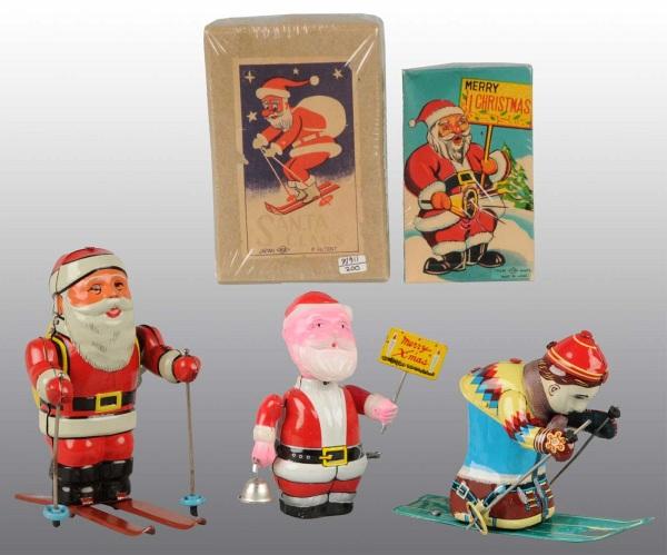 Lot of 3: Tin Litho Santa Claus & Skiing Toys.: Japanese. Working. Includes one Santa holding Christmas Sign with celluloid head, one Skiing Santa with detachable skis, and one Civilian Skier. Very little wear overall. Includes two original boxes f
