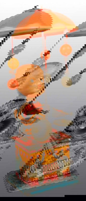 Tin & Celluloid Musical Wind-Up Toy.: Japanese. Pre-war. Working. Tin figure with celluloid head that has arms that move up and down to hit cymbals. When in operation, umbrella spins around. Nice lithography with moderate fading, scratchi