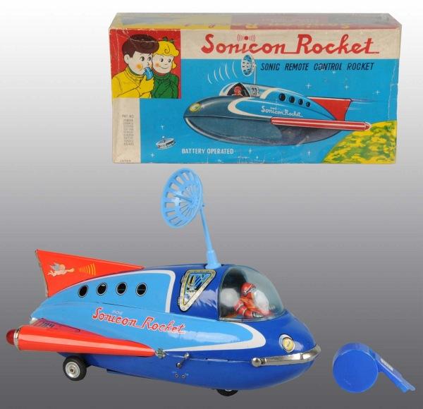 Tin Litho Sonicon Rocket Battery-Operated Toy.: Japanese. Working. Original radar dish and whistle. No cracks to plastic bubble. Includes original box with some creasing and wear. 14" L. (Very Good).