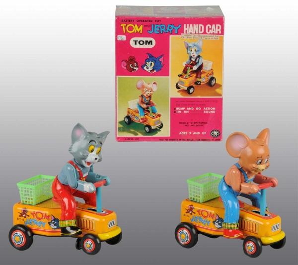 Lot of 2: Tin & Vinyl Tom & Jerry Battery-Op Toys: Japanese. Working. Includes one Tom and one Jerry handcar with vinyl heads. Very little wear overall. Includes one original box for Tom toy. Each: 7 - 3/4" L. (Very Good - Excellent).