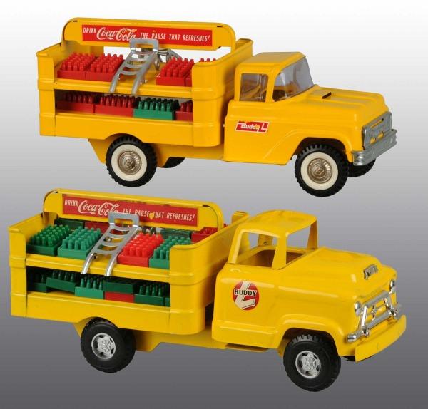 Lot of 2: Pressed Steel Buddy L Coke Truck Toys.: American. Includes one with rounded GMC cab and the other with a square cab. Both with metal dollies and plastic soda trays. Very little wear to toys but some chipping to decals. Each: 14 - 1/2" L. (V