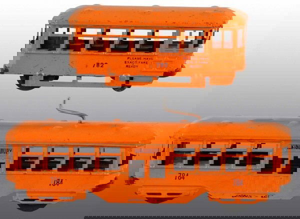 Lot of 2: Tin Kingsbury Trolley Car Wind-Up Toys.: American. Working. Smaller car is numbered "782" on both sides with wind-up on bottom and larger car is numbered "784" on both sides with unusual crank mechanism on roof. Some scratching and wear, esp