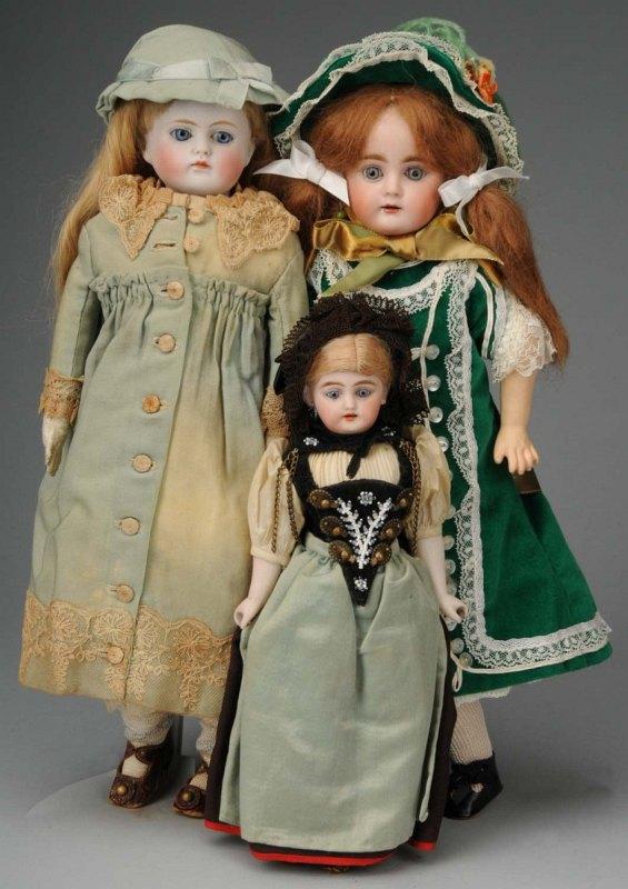 Lot of 3: Bisque Head Dolls.: Germany, Ca. 1900. Simon & Halbig shoulder head, blue glass eyes, multi-stroked eyebrows, open mouth with upper teeth, blonde mohair wig with braids, cloth body with bisque lower arms, all original in
